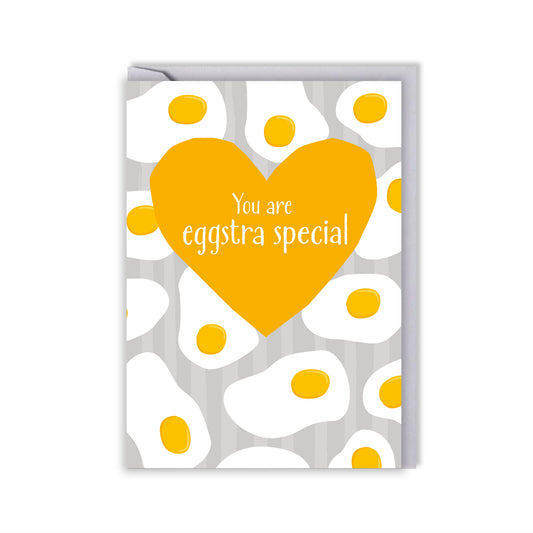 grey striped background with a pattern of fried eggs. a yellow heart and the wording your are eggstra special 